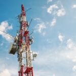 Low angle view of Antenna tower against a blue sky. 5g network cell tower.