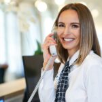 Receptionist answering phone at hotel front desk
